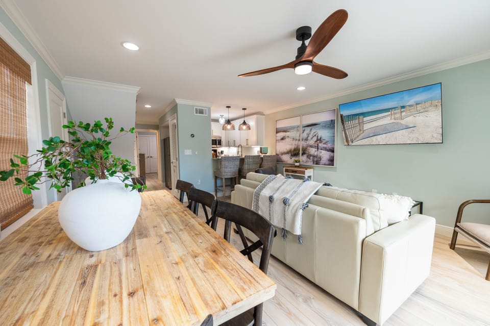 Cozy beach-themed living room with chic decor, wood table, and bold wall art.