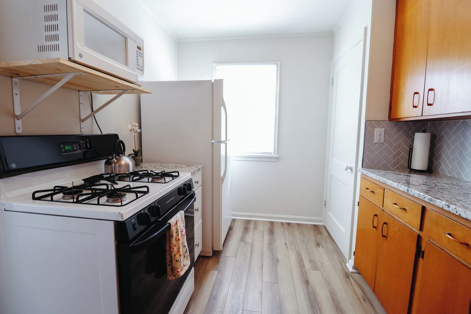 Kitchen with stove, refrigerator and microwave oven. 