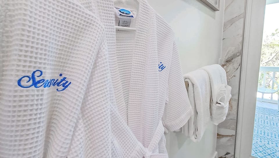 Details in every corner. Slip into the Serenity spa robes or Step into your spa-like bathroom oasis, featuring a rain shower, soothing stones, and a luxurious soaking tub that mimics the tranquility of the ocean.