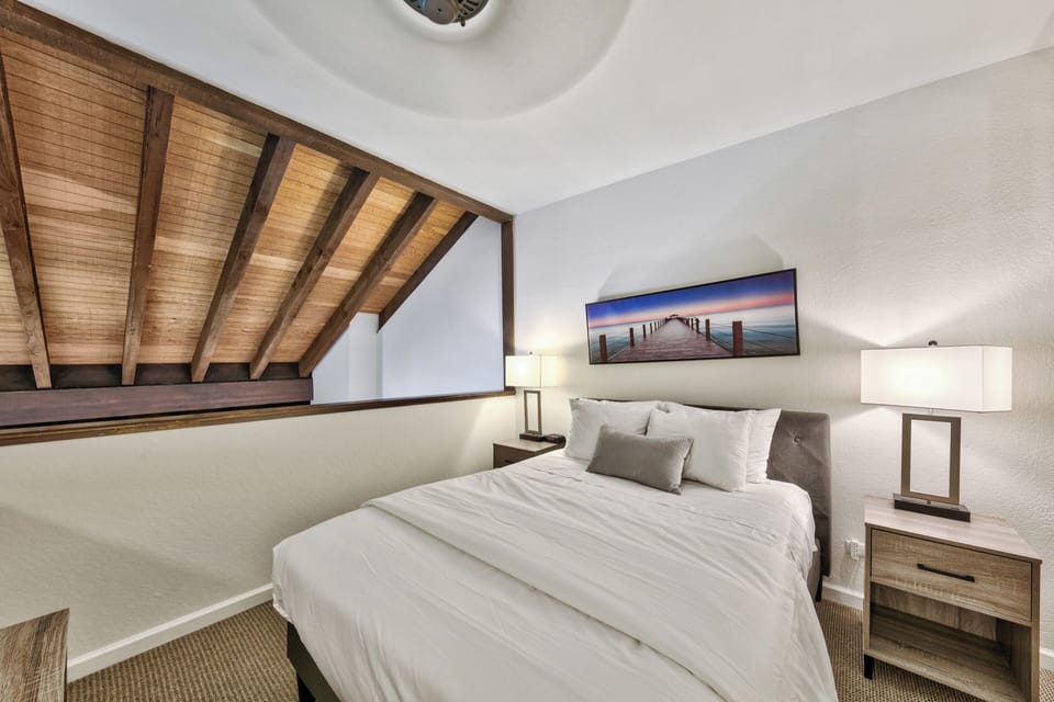 Drift off under exposed wooden beams in your cozy loft bedroom, where modern comfort meets rustic charm.