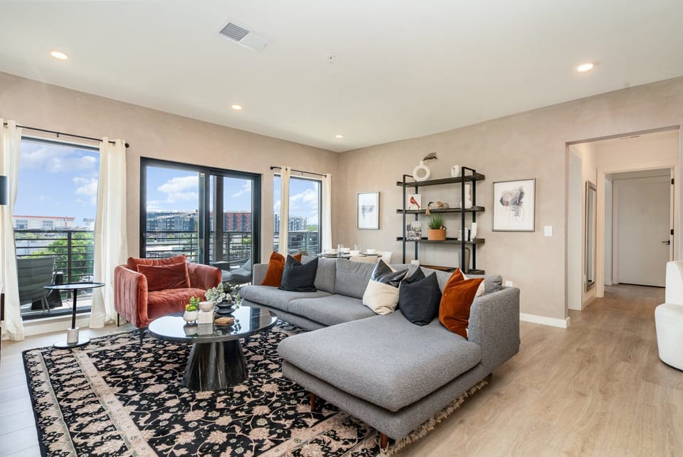 Bright open living space that features a smart TV, dining area, and entrance to a private patio.