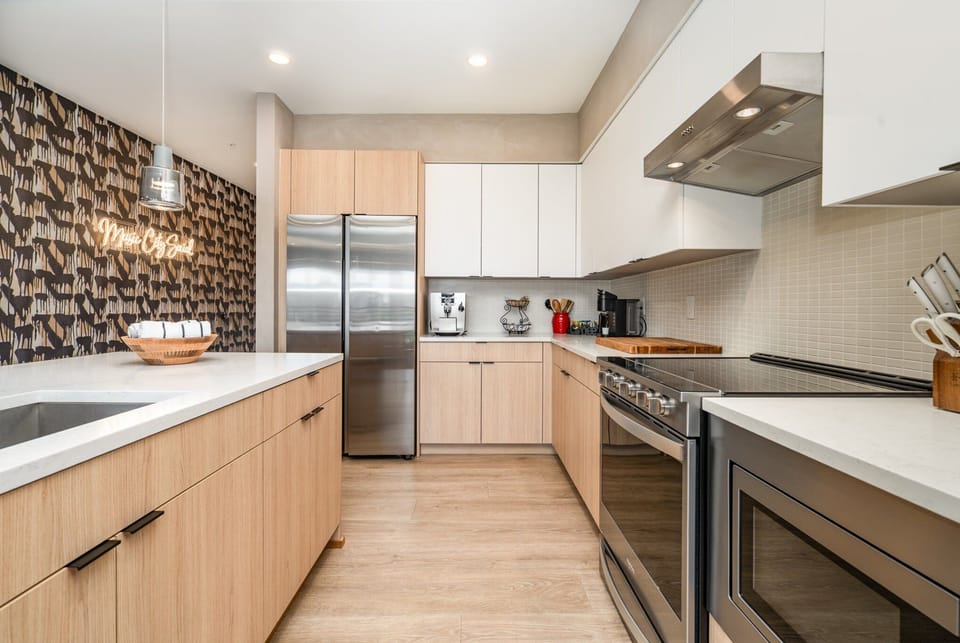 Fully equipped modern kitchen featuring culinary essentials, stainless steel appliances, and island bar seating.
