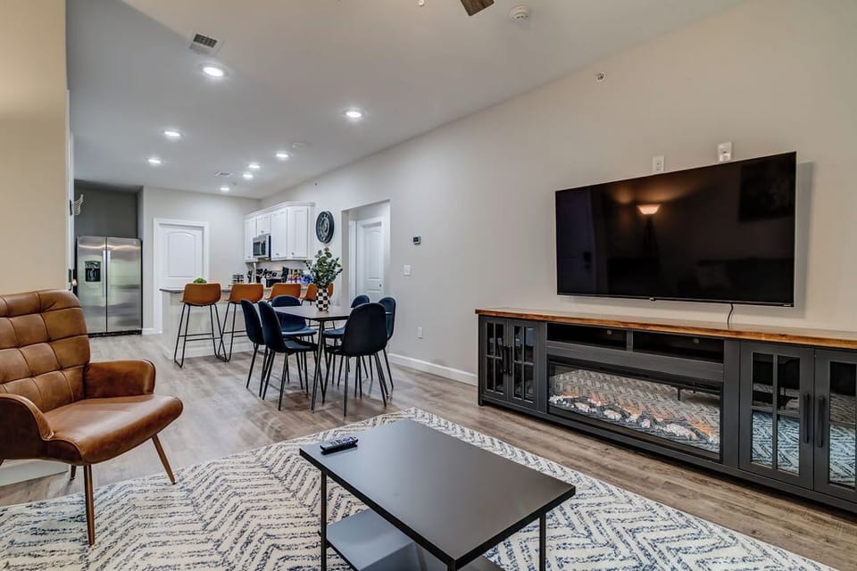 Open concept living room with smart television and electric fireplace.