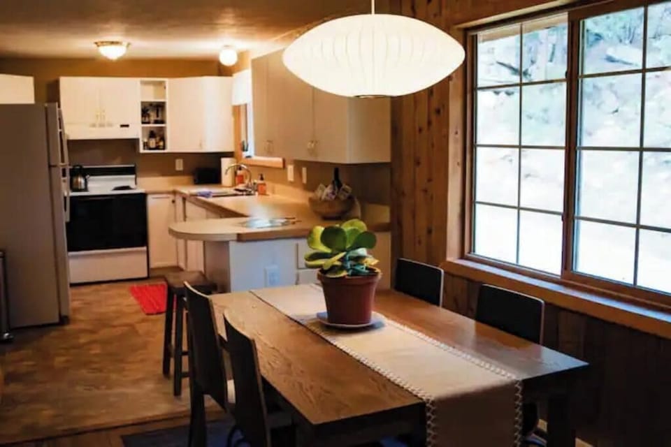 Vaulted ceiling and open floor plan. Dining table looks out to boulder hillside.
