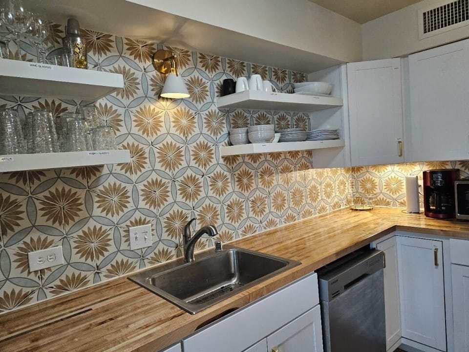 Fully stocked kitchen with dishes, glasses, pots, pans and serving dishes