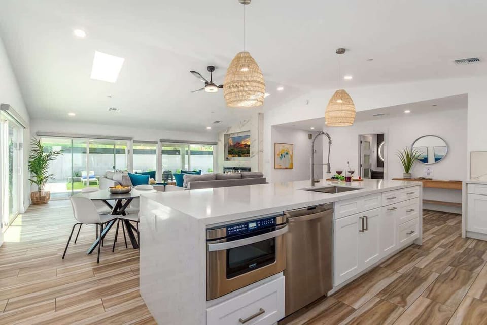 Fully equipped kitchen boasting high-end stainless-steel appliances, a large island offering bar seating, and a breakfast table.