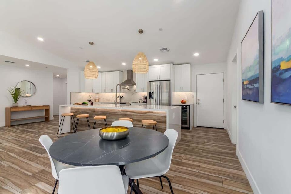 Fully equipped kitchen boasting high-end stainless-steel appliances, a large island offering bar seating, and a breakfast table.