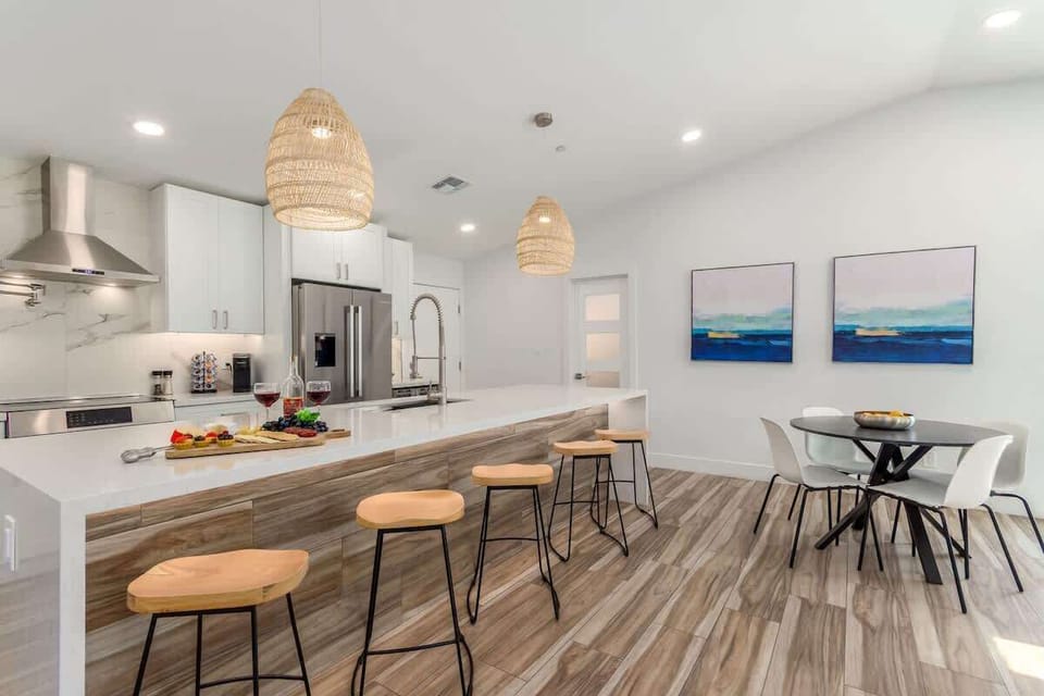 Fully equipped kitchen boasting high-end stainless-steel appliances, a large island offering bar seating, and a breakfast table.