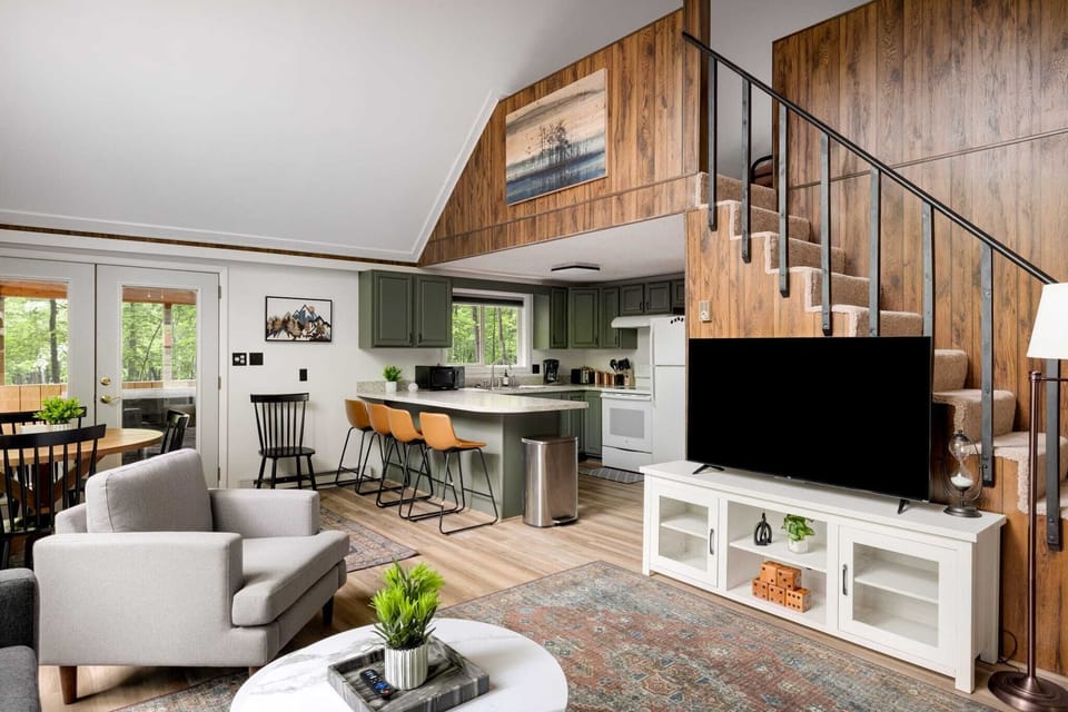 Cozy living area with a modern kitchen and staircase leading to the upper level.