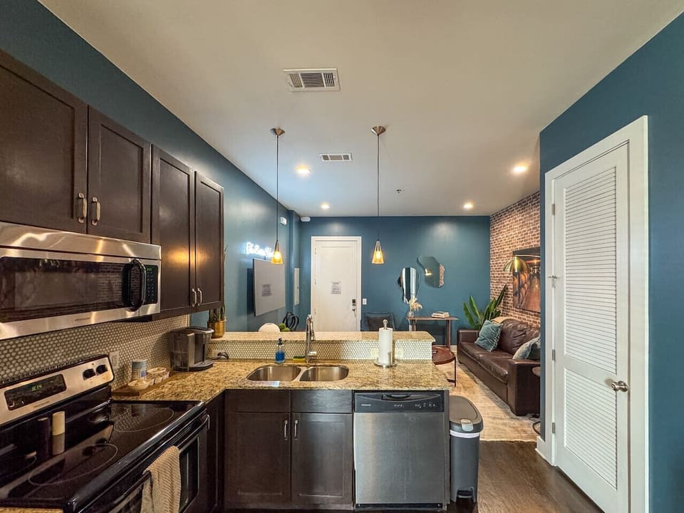 The adjacent kitchen continues the industrial-modern theme, seamlessly integrating into the living area.