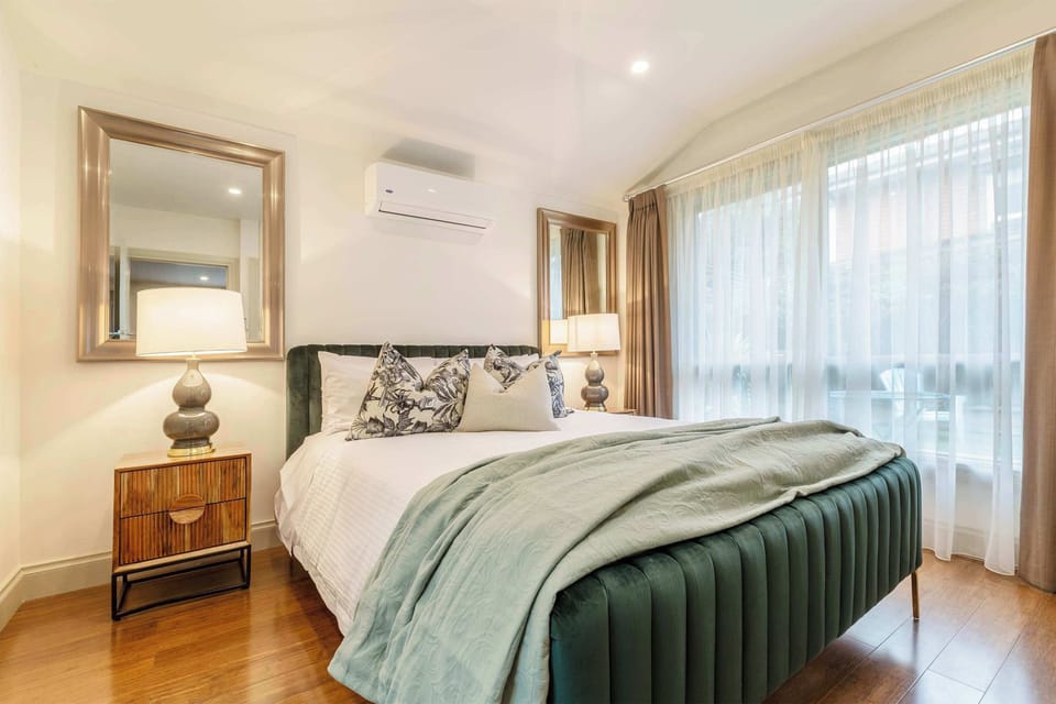 BEDROOM: Unwind in this serene retreat featuring a plush bed, layered with crisp linens and soft pillows for ultimate comfort