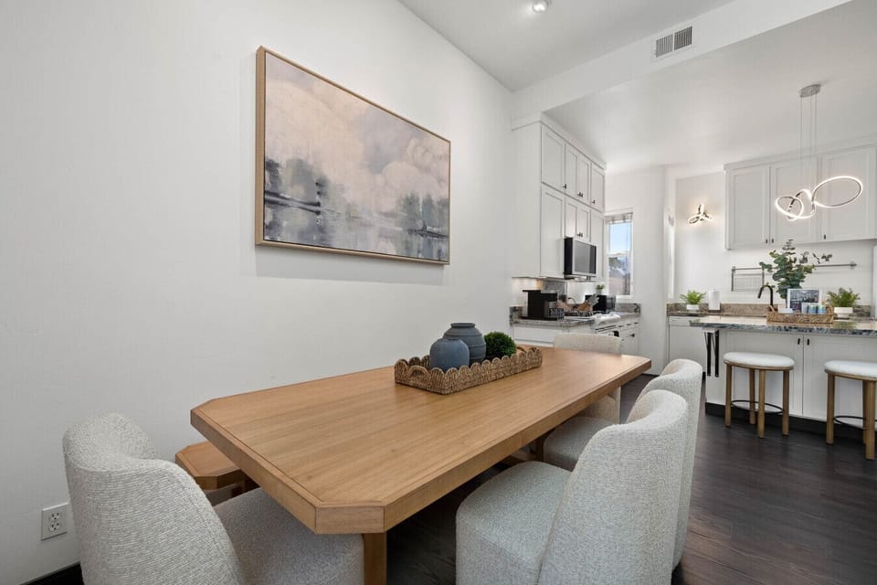 Dining area w/ a warm wood table, clean lines & an easy flow into the living space.