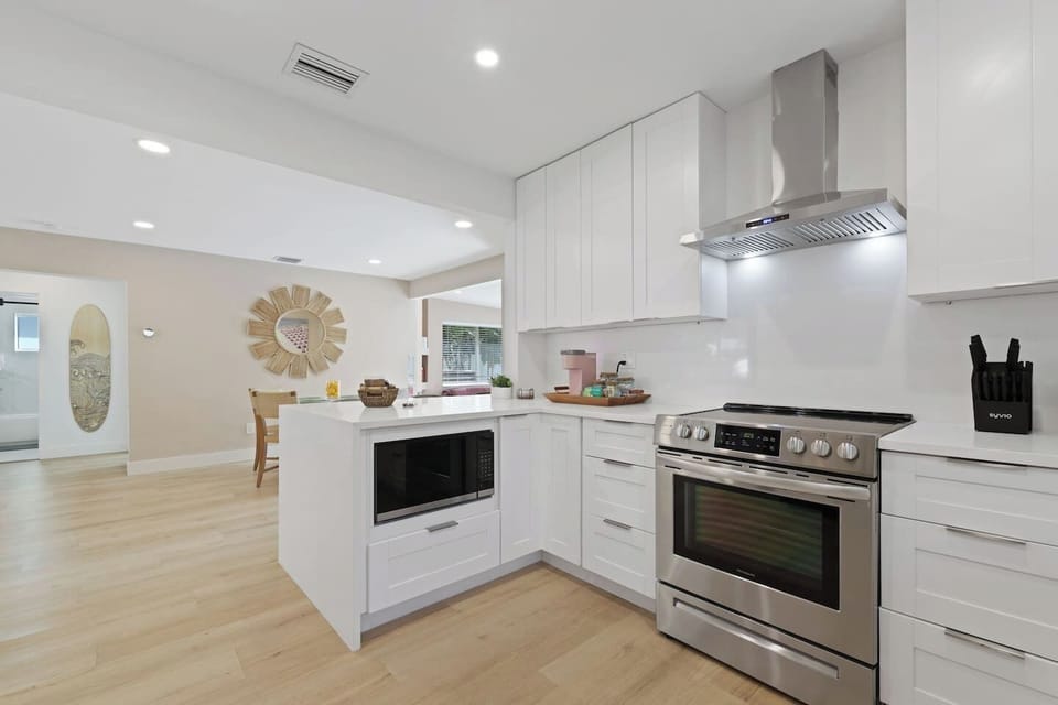 Modern elegance meets culinary convenience in our pristine kitchen. Whip up delights with top-notch appliances surrounded by sleek white cabinets. 