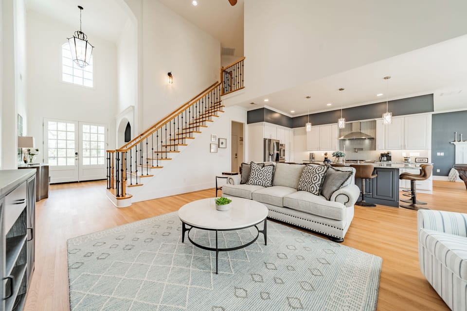 Living room with couch, chairs, TV and view of the lake.