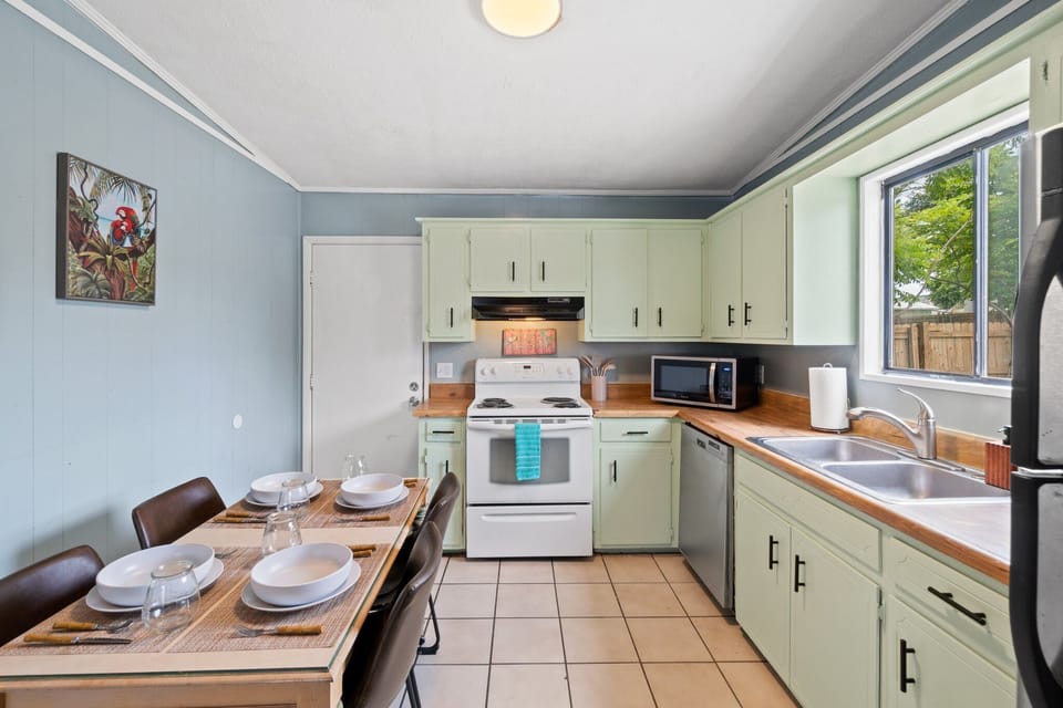 Kitchen is stocked with an abundance of plates, cups, pans, and cooking utensils