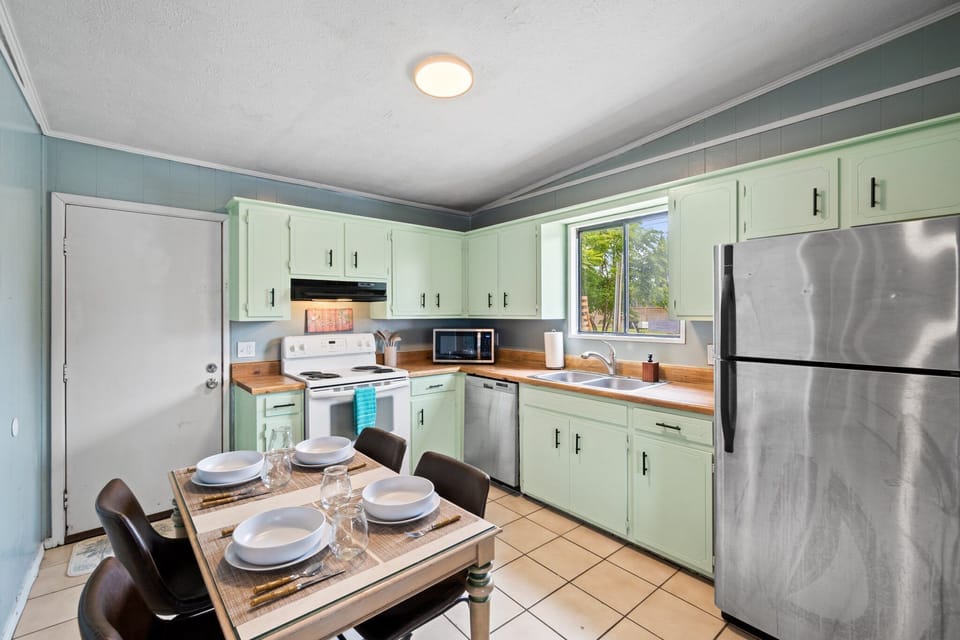 Kitchen is stocked with an abundance of plates, cups, pans, and cooking utensils