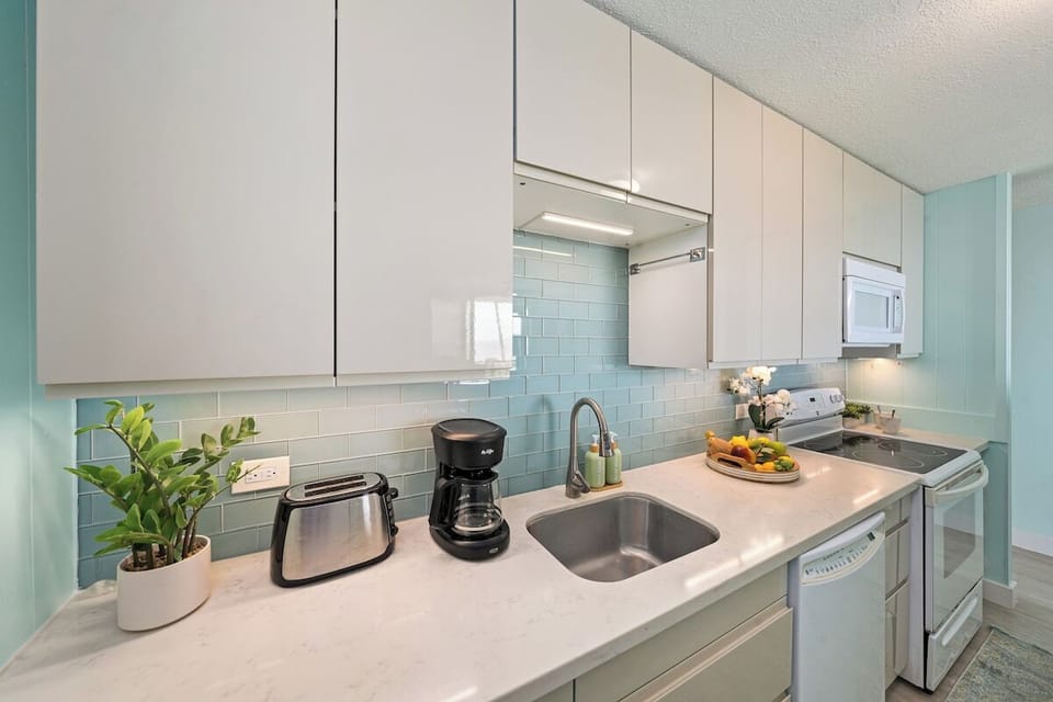 A bright modern kitchen with white cabinetry, stainless appliances, and fresh coastal accents.