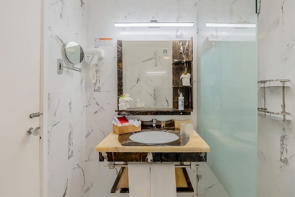 Rinse off in the bright marble bath after beach days.
