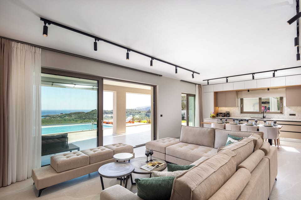 The living room area features a lush corner sofa, comfortably seating 11 guests, with a PlayStation 5, Bluetooth speaker, and a 65” Smart TV.