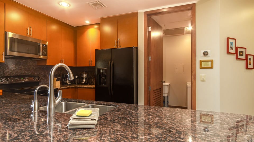 Granite counter compliments the cabinets, and accents the dark appliances as well.