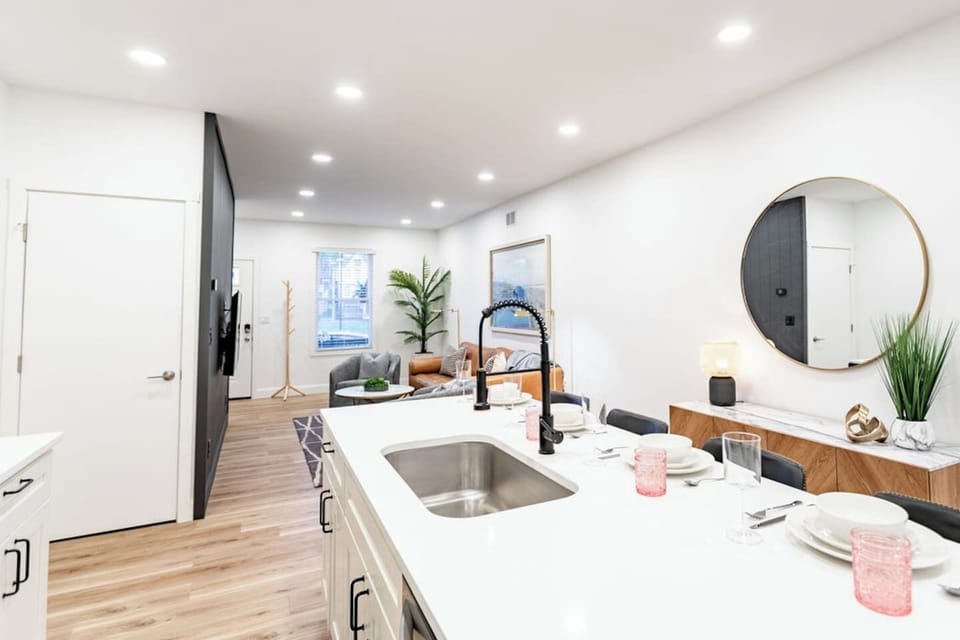 Full view of the kitchen counter, featuring a stylish circular mirror and a set of plates for dining.
