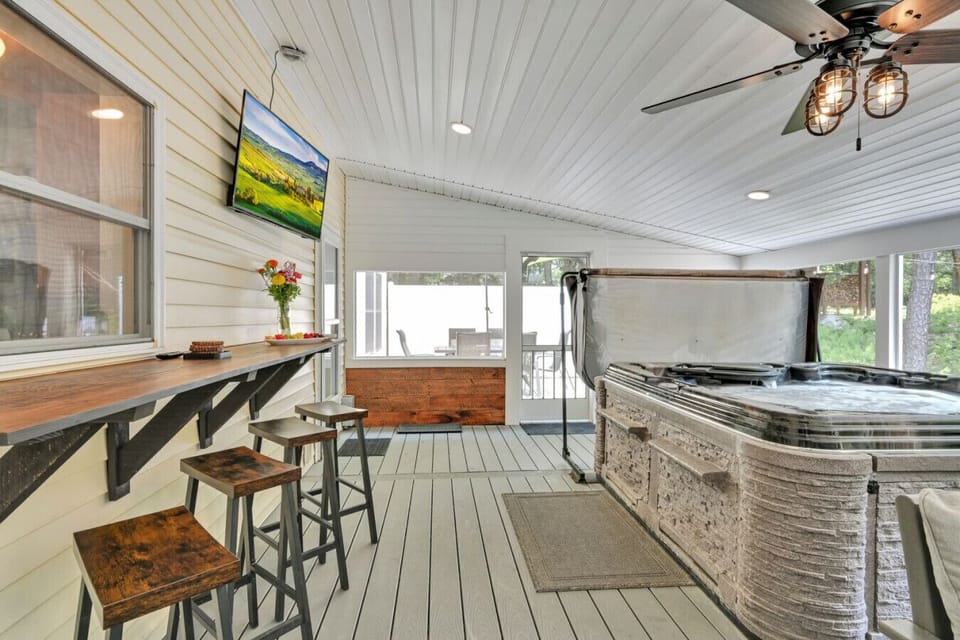 Hot tub,seating, and smart TV in screened porch.