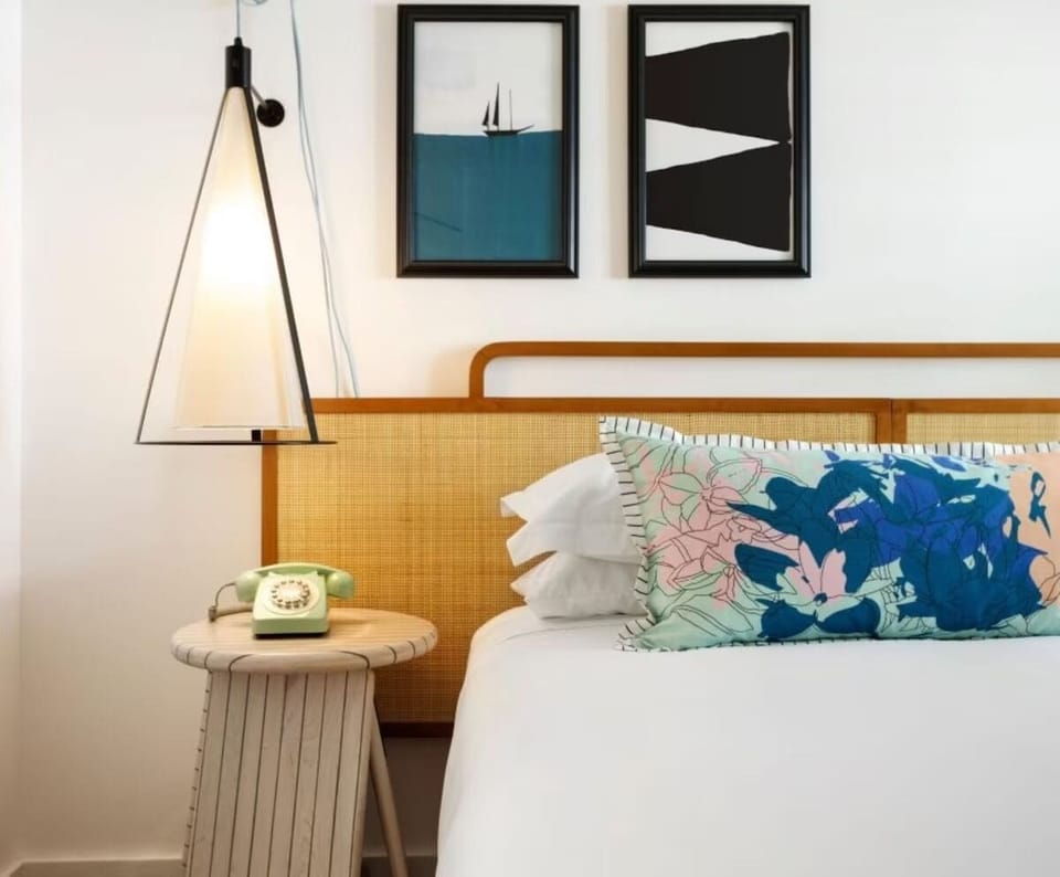 Drift off beneath curated art and warm, ambient bedside lighting.