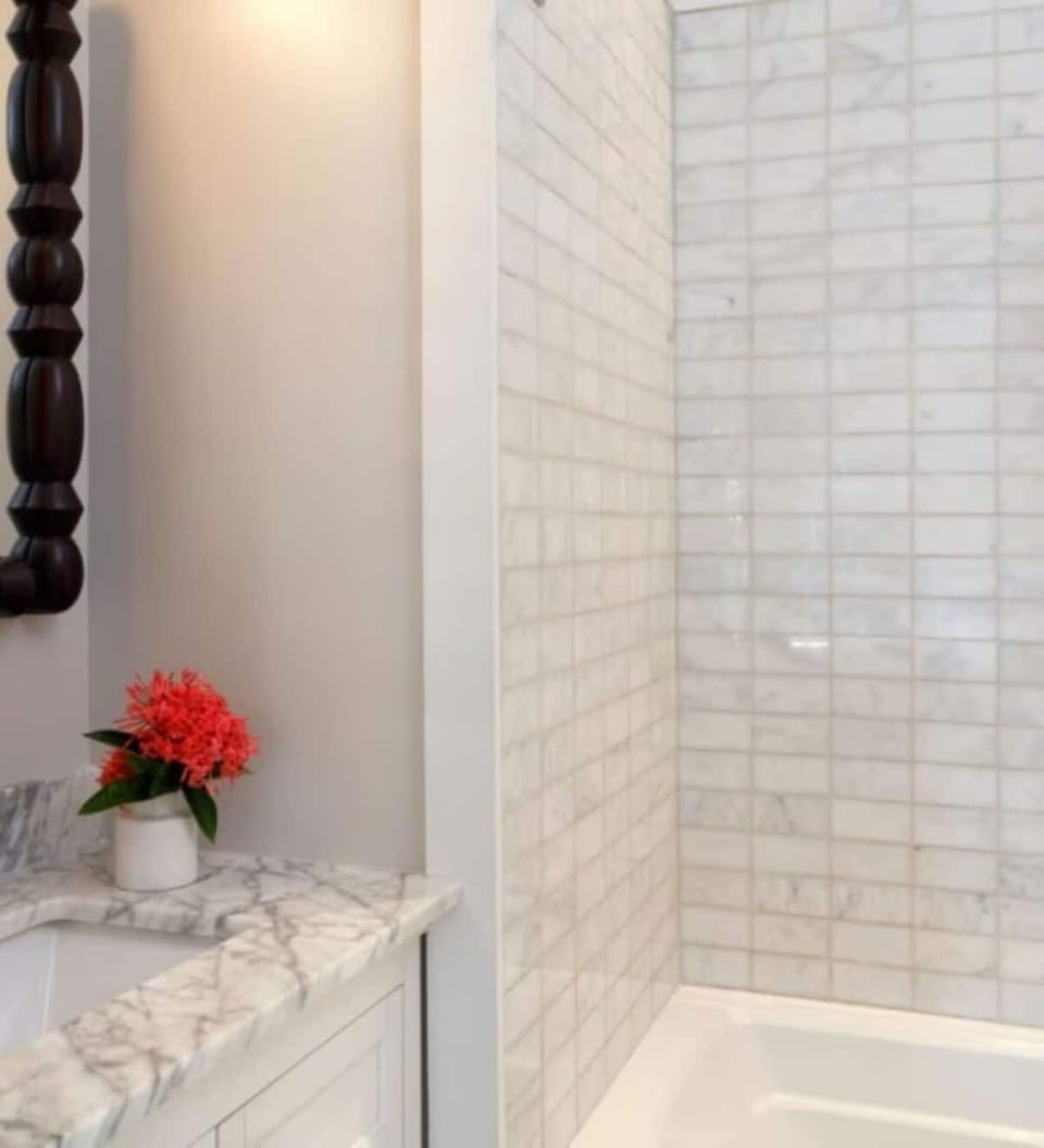 Refresh in a bright, marble-topped bath with sleek tile.