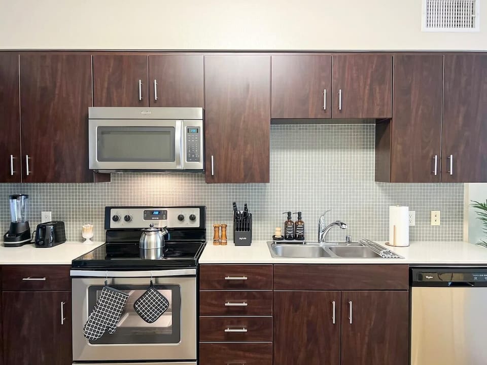 Enjoy a fully equipped kitchen for long-term comfort, featuring a stovetop, convenient microwave, refrigerator with freezer, a complete knife set, quality pots and pans, dinnerware and glassware, and all essential kitchen utensils.