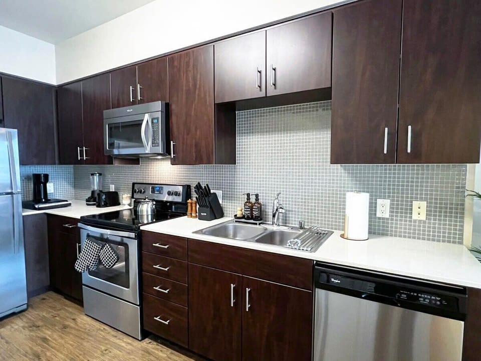 Enjoy a fully equipped kitchen for long-term comfort, featuring a stovetop, convenient microwave, refrigerator with freezer, a complete knife set, quality pots and pans, dinnerware and glassware, and all essential kitchen utensils.