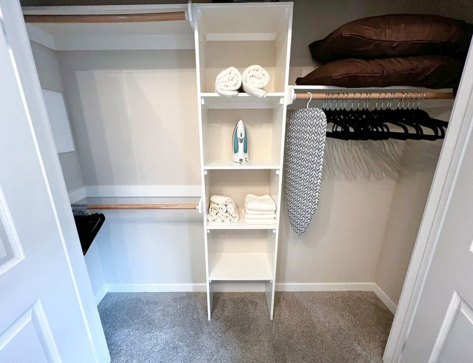 Large walk-in closet with an iron and ironing board