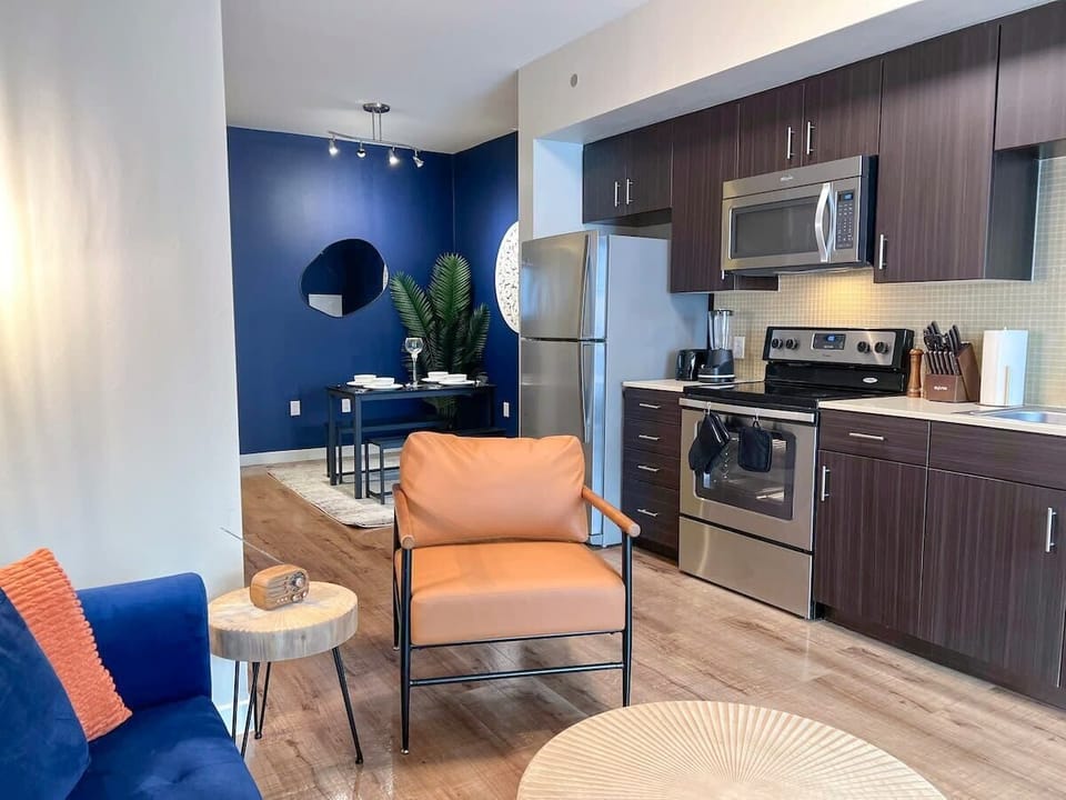 An open-concept apartment where the dining area seamlessly flows into a cozy living space and a comfortable bed area.