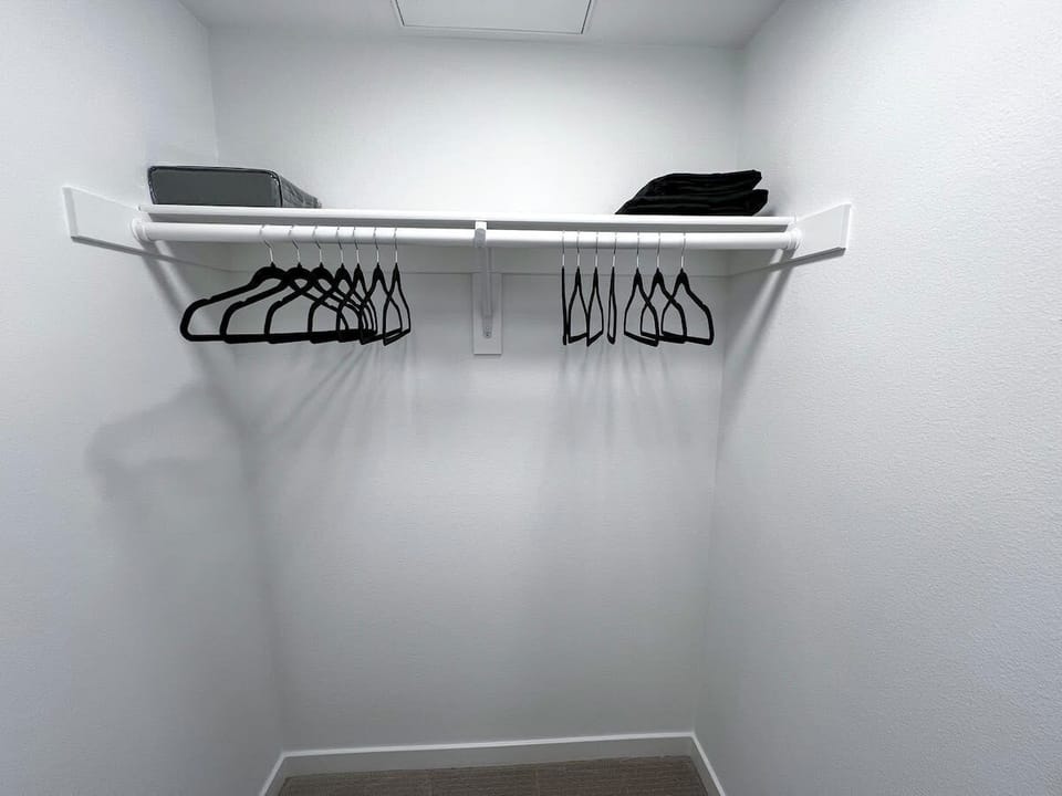 Spacious walk-in closet featuring ample hangers and stocked with extra towels.