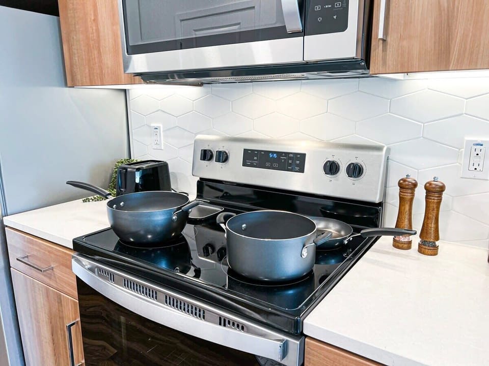 Modern kitchen amenities for extended stays: stovetop, fridge, dishwasher, microwave, kettle, toaster, blender, and a full knife set.