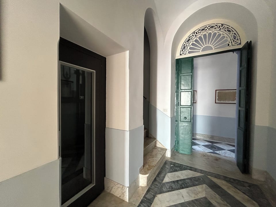 The hallway at Iris Blu with the elevator on the left and doorway to stairs. . 