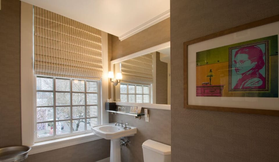 Refresh in the stylish bathroom, highlighted by contemporary fixtures, ample natural light, and chic artwork.