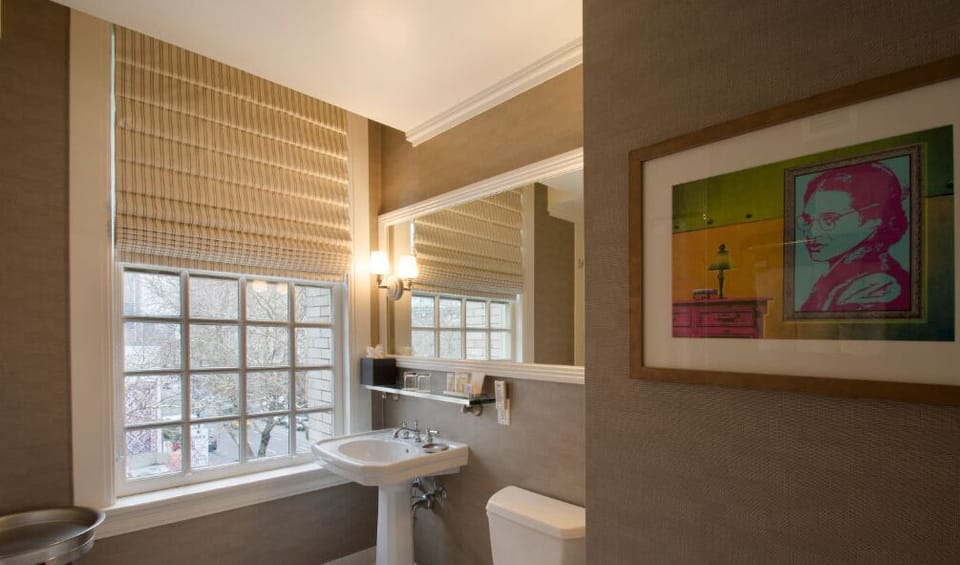 Refresh in the stylish bathroom, featuring contemporary fixtures, abundant natural light, and chic artwork.