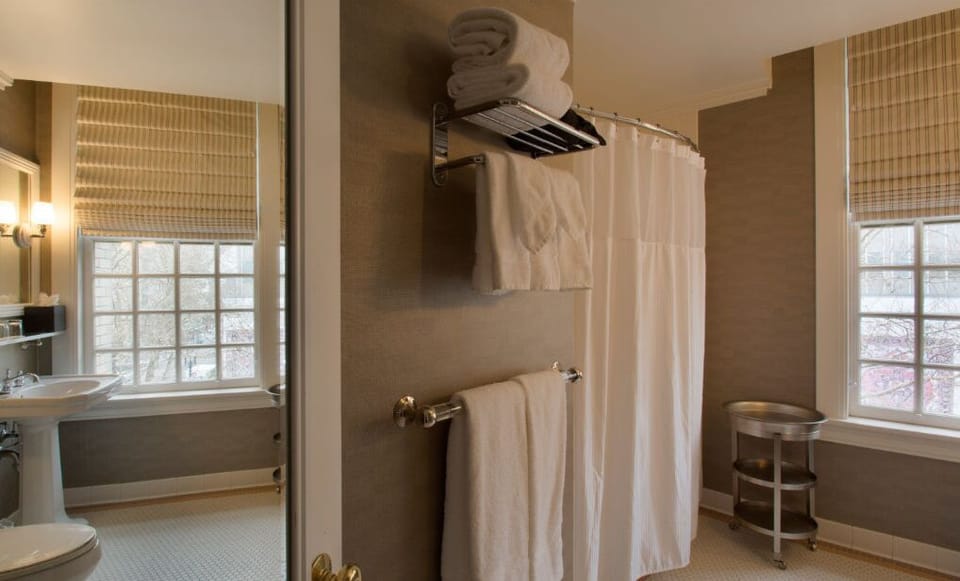 Enjoy a spacious shower experience in this well-appointed bathroom with elegant design and ample lighting.