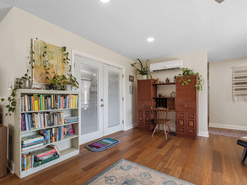 View of living area with wall unit that has a fold down desk.