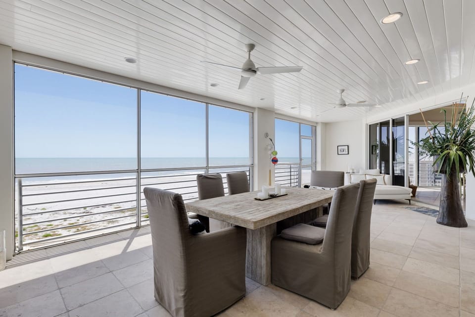 Main level lanai (off living room) with dining area with service for 6 guests, direct beachfront with sliders that can be opened to enjoy your meals a la beach