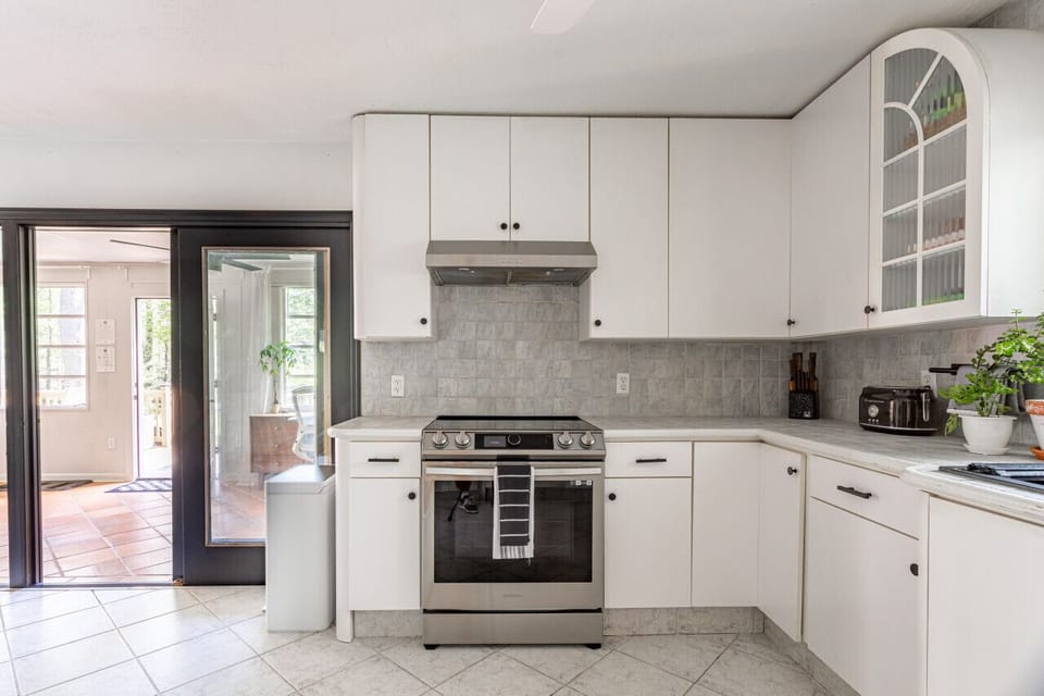 Kitchen includes new stainless steel appliances and access to sun room area