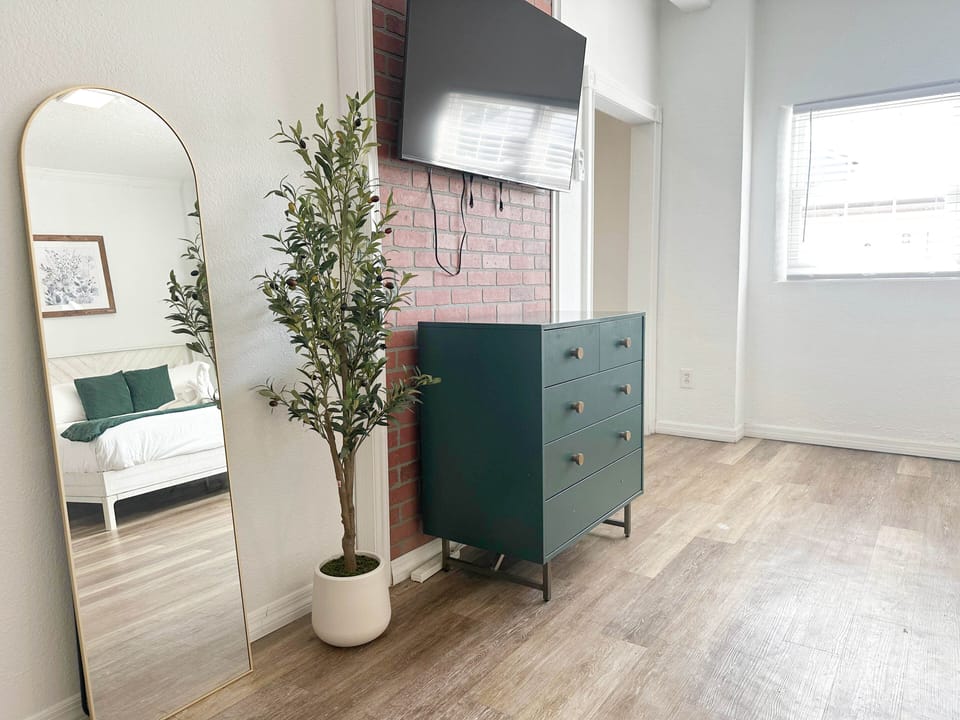 Stylish dresser and mirror setup with cozy touches.