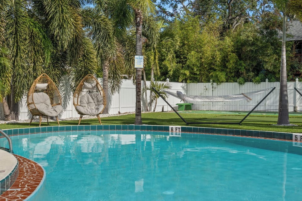 Refreshing outdoor pool surrounded by palm trees.