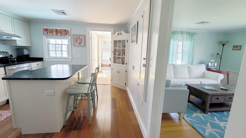 Kitchen with door to living room and hall to family room