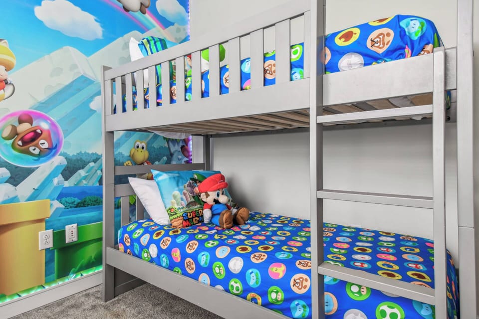 Bright colors fill this fun bunk bed area, with vibrant bedding showcasing beloved characters that ignite excitement. A unique wall mural adds whimsy, crafting a delightful space for kids to relax and dream.