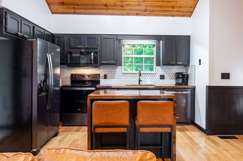 Fully equipped modern kitchen with sleek black appliances and cozy breakfast bar!