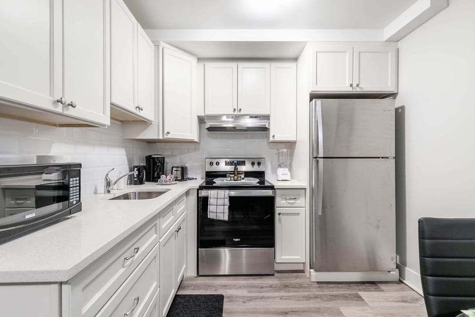 Modern kitchen fully equipped with stainless steel appliances and essential cookware