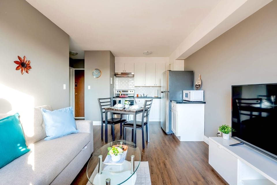 Spacious Living Area Featuring A Comfortable Sofa Bed, A Smart TV, And Access To A Bright Balcony