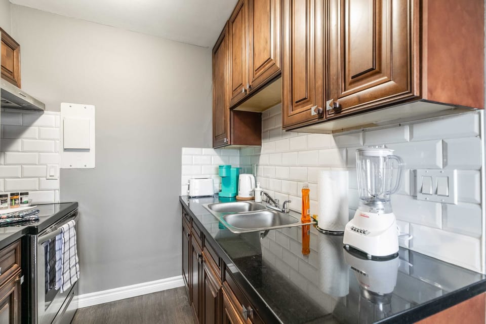 Bright Kitchen Equipped With Toaster, Blender, And Kettle