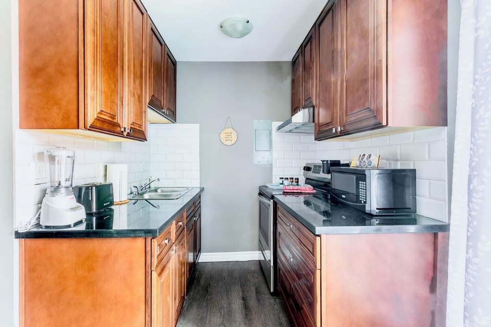 Compact And Fully Equipped Kitchen With Warm Wooden Cabinetry